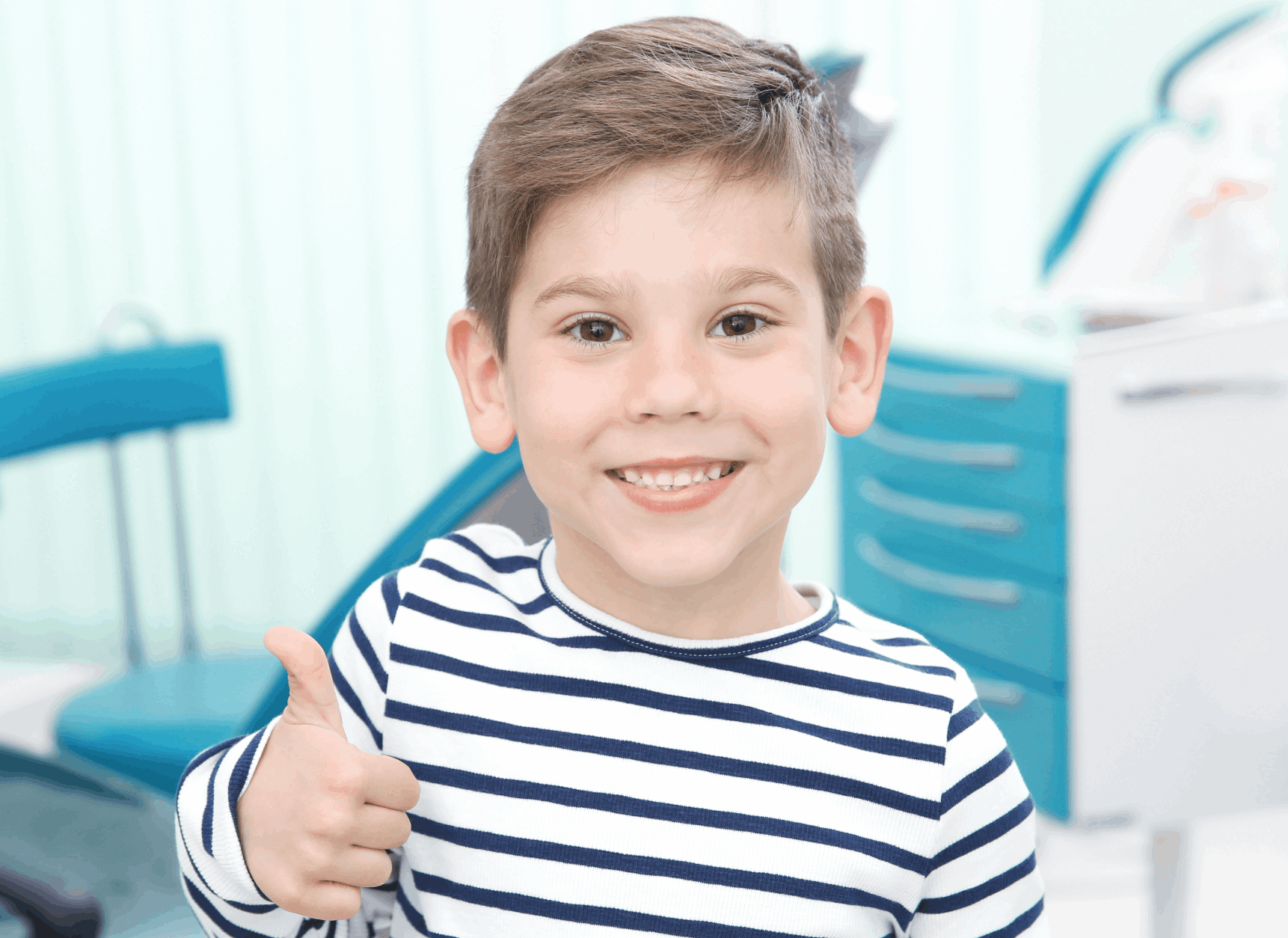 Child smiling and making a thumbs up